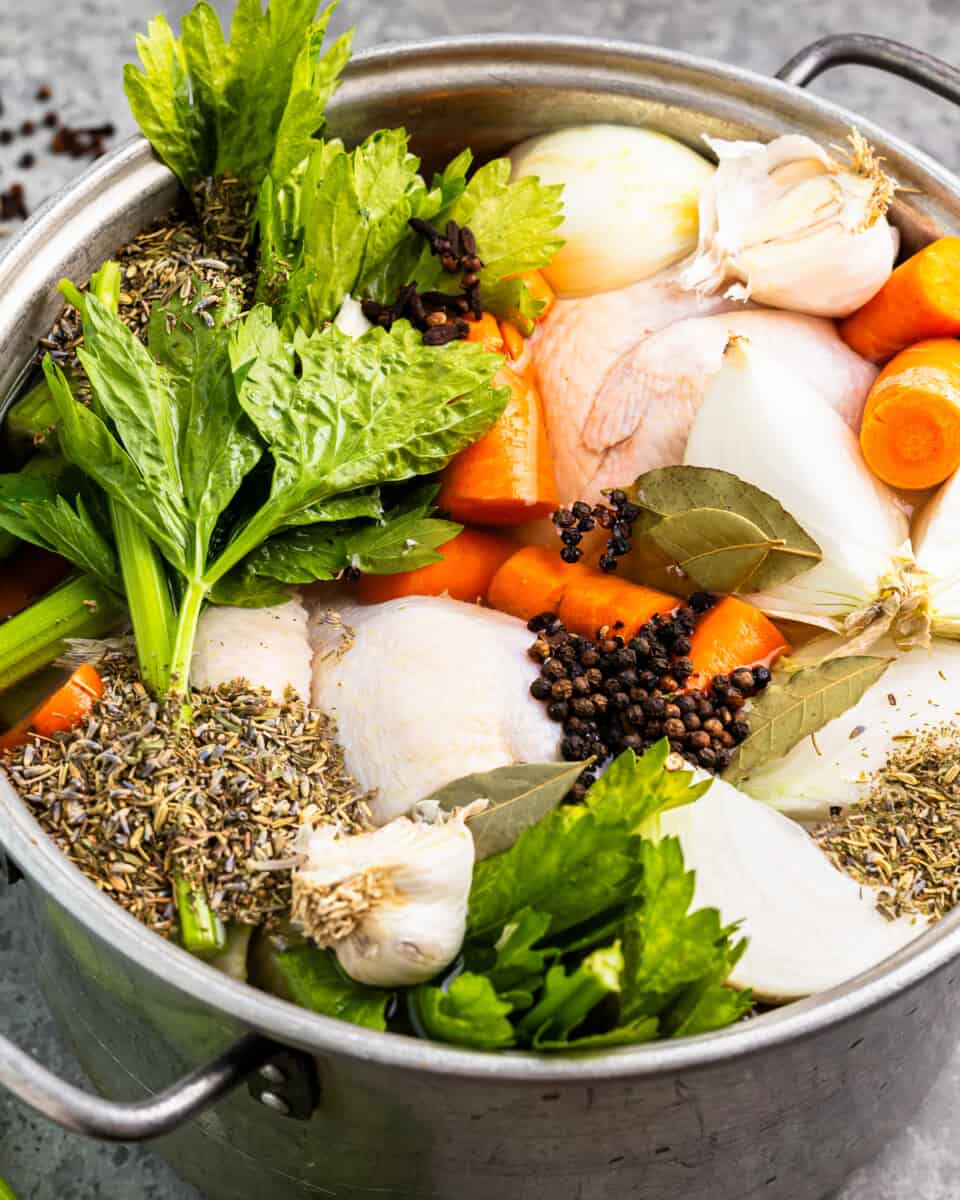A pot filled with vegetables and herbs.