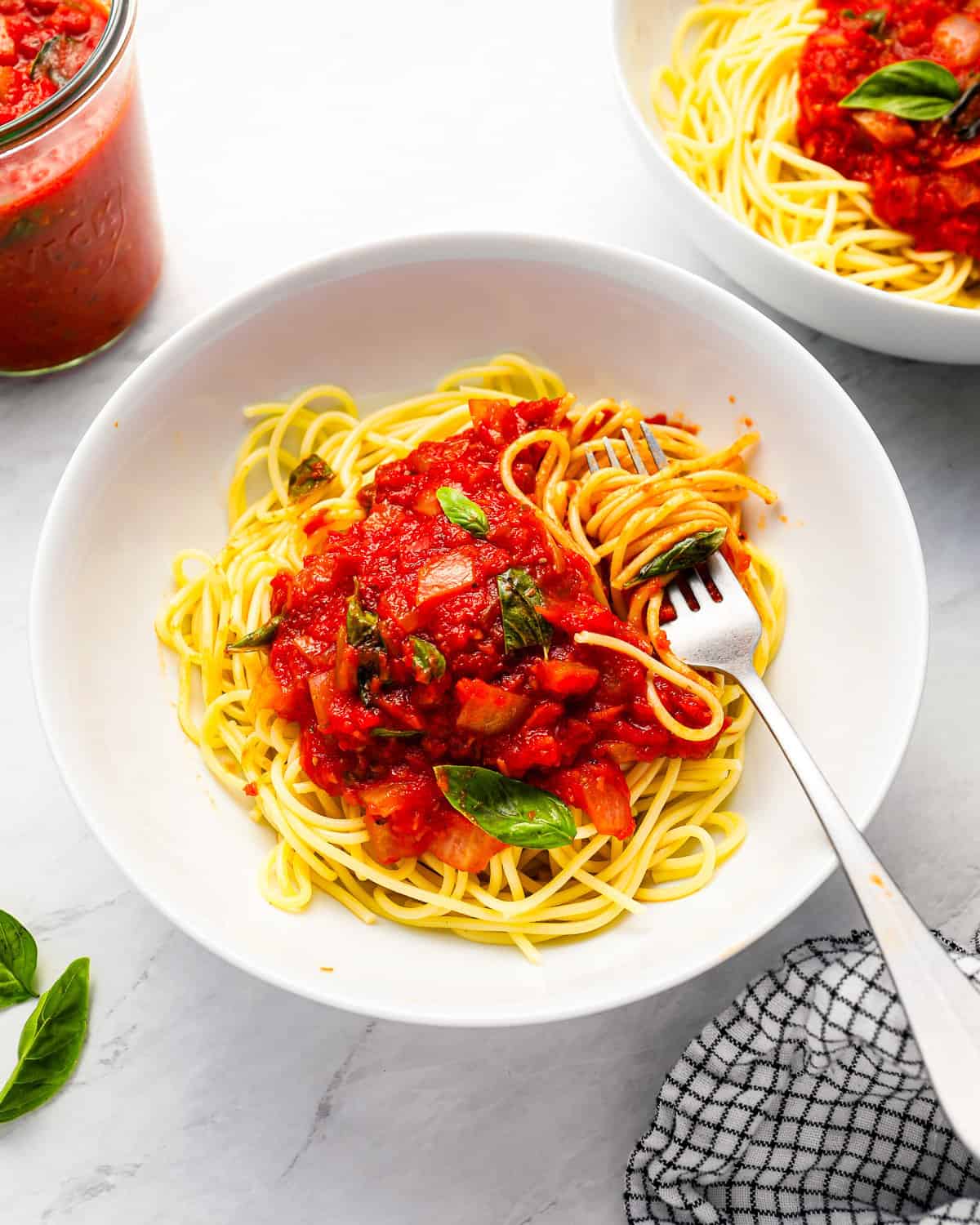 A bowl of spaghetti with tomato sauce and a fork.