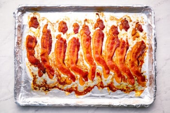 A baking sheet with bacon on it.