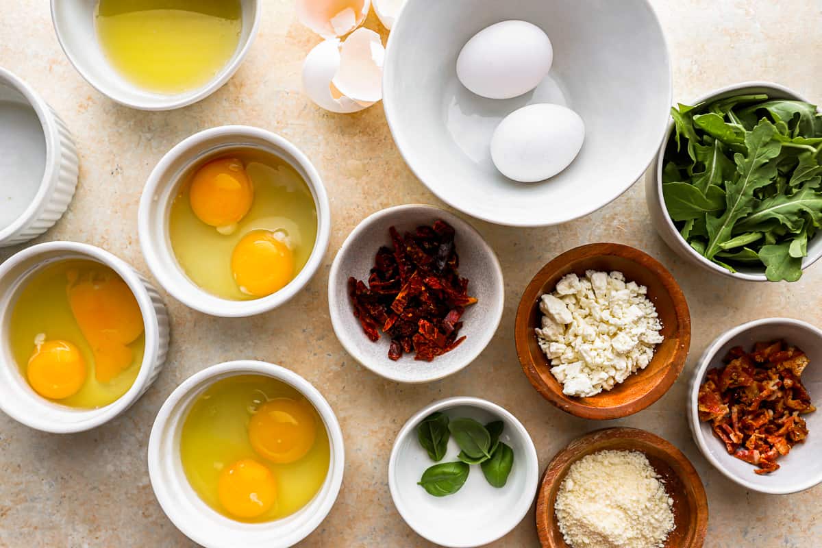A bowl of eggs, spinach, and other ingredients on a table.