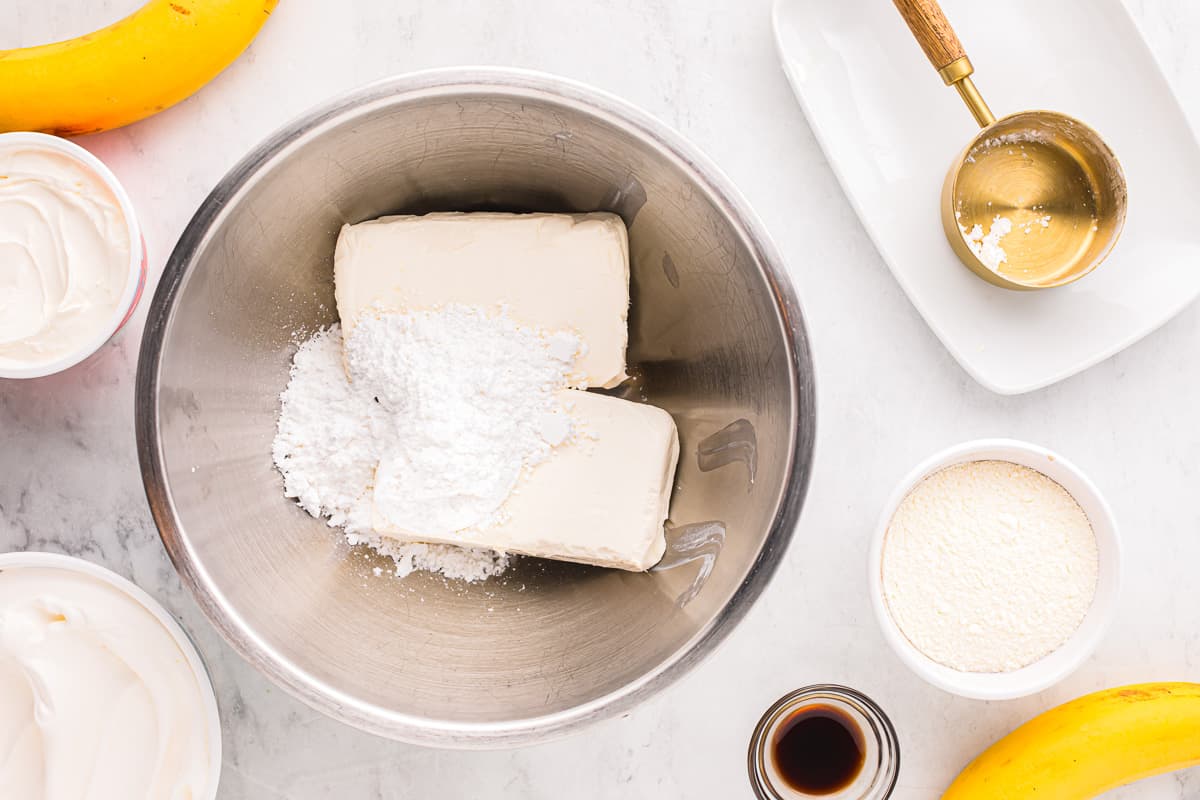 Ingredients for banana bread in a bowl on a marble countertop.