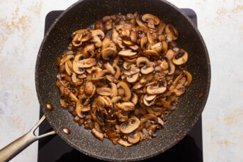 Mushrooms in a frying pan on a stovetop.