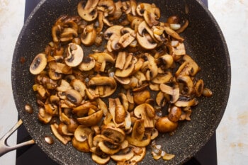 Mushrooms in a pan on a stovetop.