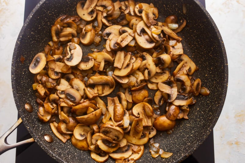 Mushrooms in a pan on a stovetop.