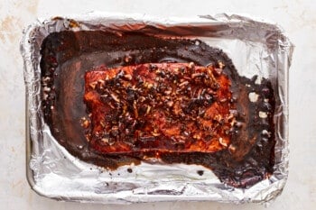 A piece of salmon in foil on a table.