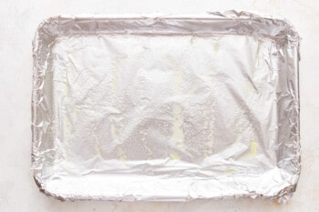A square baking pan covered in aluminum foil.