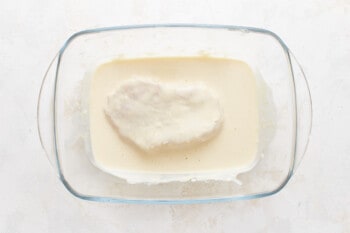 A glass bowl filled with cream and a heart shape.