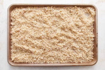 A baking pan filled with sifted granola.