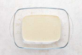A glass bowl with a square of cream in it.