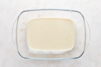 A glass bowl with a square of cream in it.