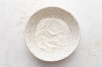 White powder in a bowl on a white surface.