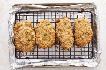 Fried chicken breasts on a baking sheet.