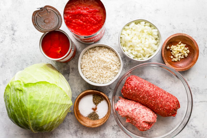 Ingredients for meatballs with cabbage and tomatoes on a white background.