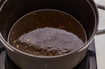 A pot filled with a black liquid on top of a stove.