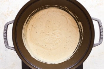 A slow cooker filled with a creamy sauce.