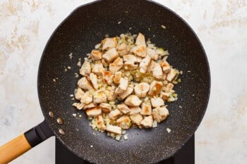 Fried chicken in a wok on a white background.