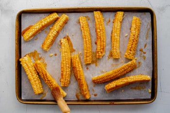 Corn on the cob cooked on a baking sheet.