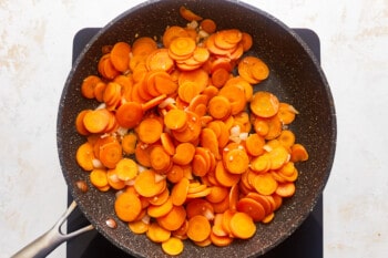 Carrots in a frying pan on a white background.