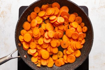 Sliced carrots in a frying pan.