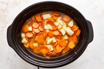 A slow cooker full of carrots and potatoes.