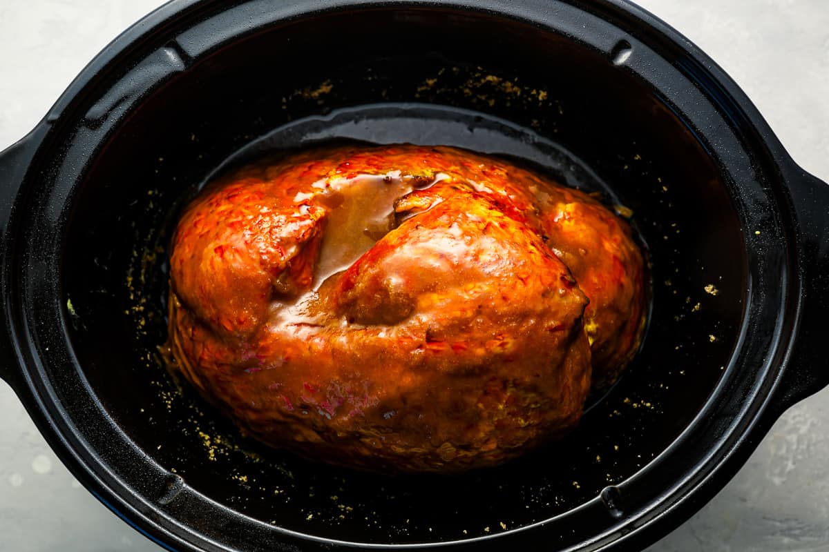 A meatball in a crock pot with sauce.