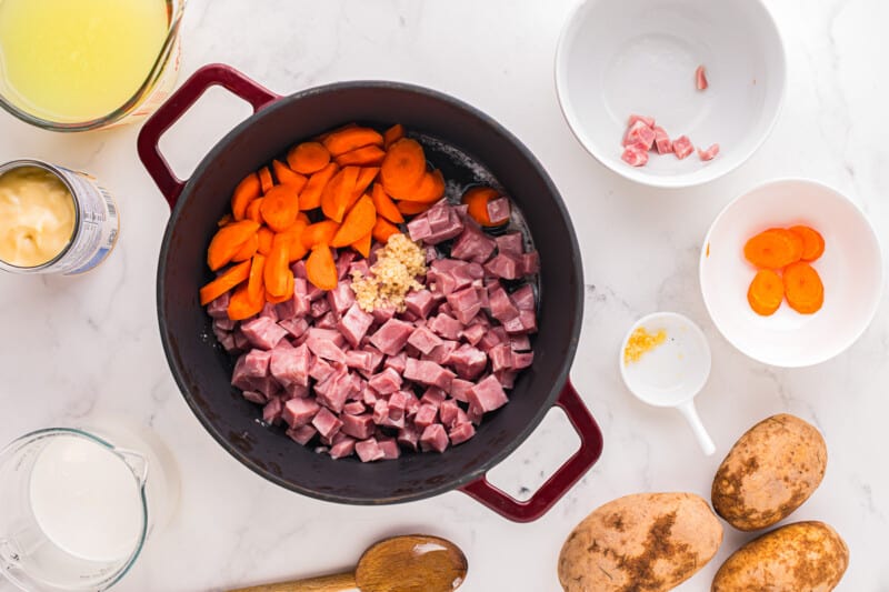 Ingredients for irish stew in a pan with carrots and potatoes.