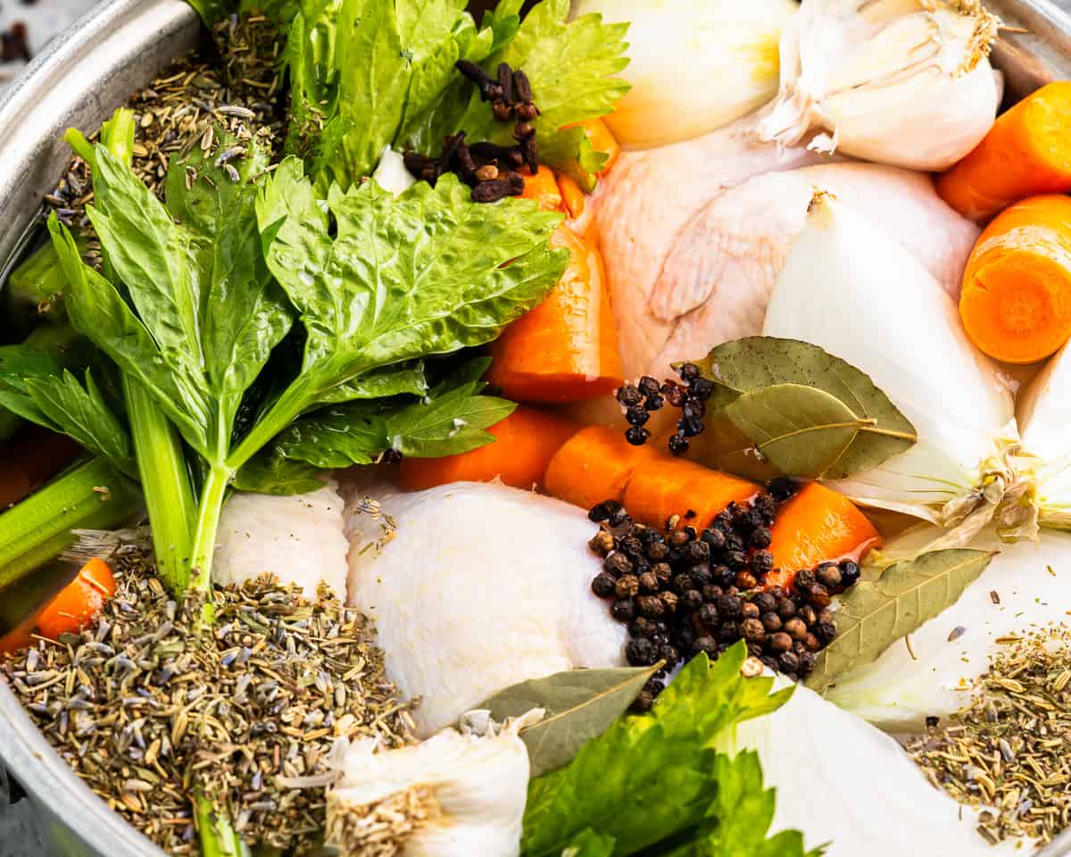 A pot filled with vegetables and herbs.