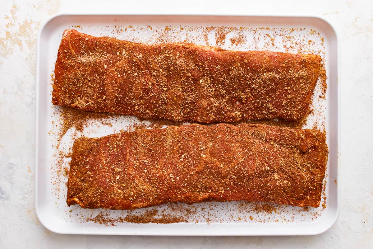 ribs coated in spices on a baking sheet.