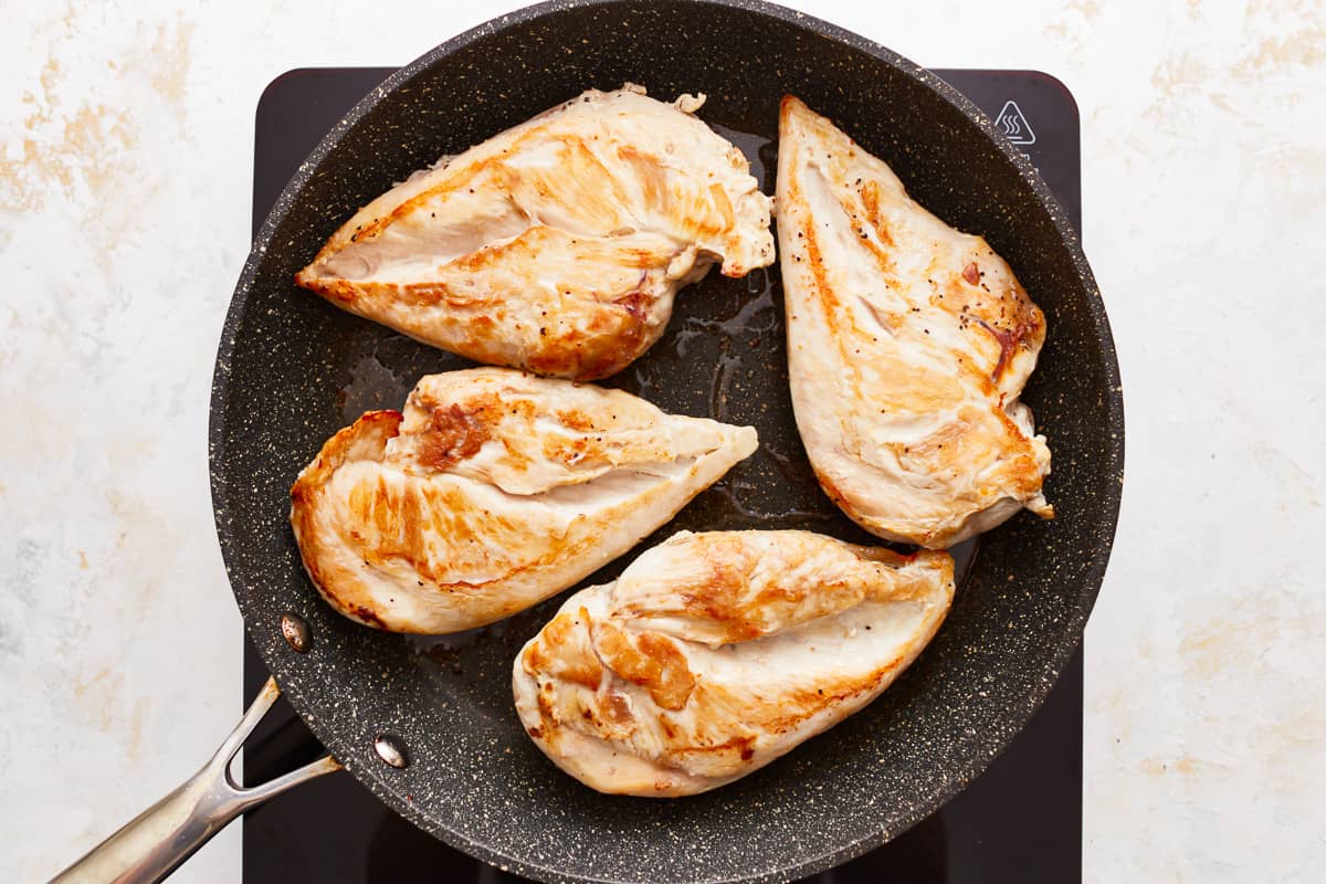 Seared chicken breasts in a skillet.