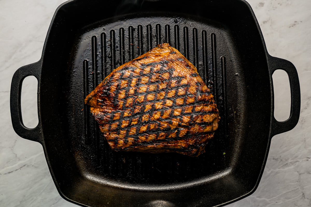 A grilled steak in a cast iron skillet.