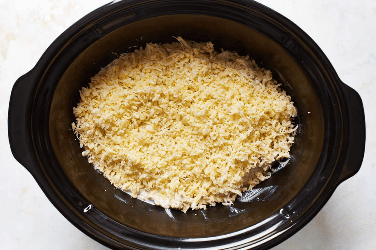 Ingredients in the crockpot topped with cheese.