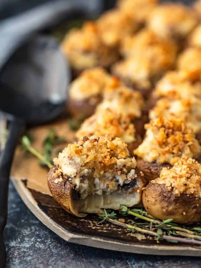 close up on sausage stuffed mushrooms, with a bite taken out of one mushroom