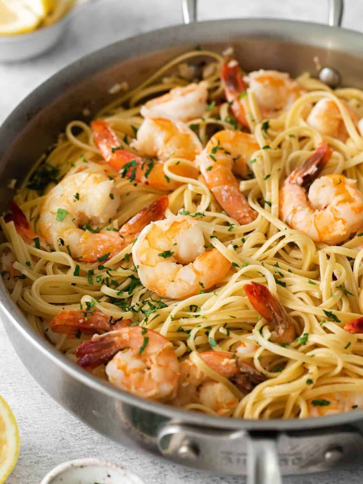 three-quarters view of shrimp scampi pasta in a frying pan.