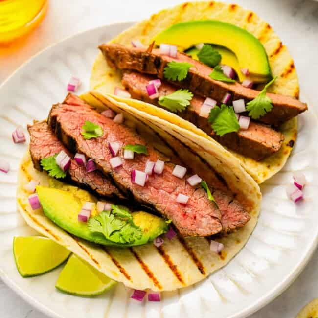 Grilled steak tacos with avocado and lime.