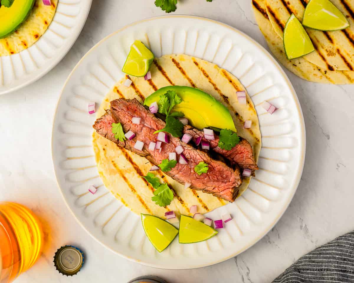 Grilled steak tacos with avocado and lime.