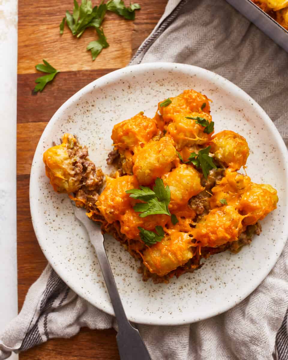 Cheesy tater tot casserole on a plate with a fork.