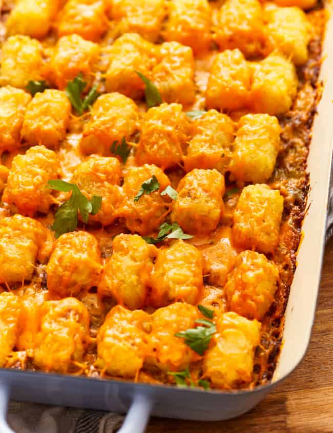 Cheesy tater tot casserole in a blue dish.