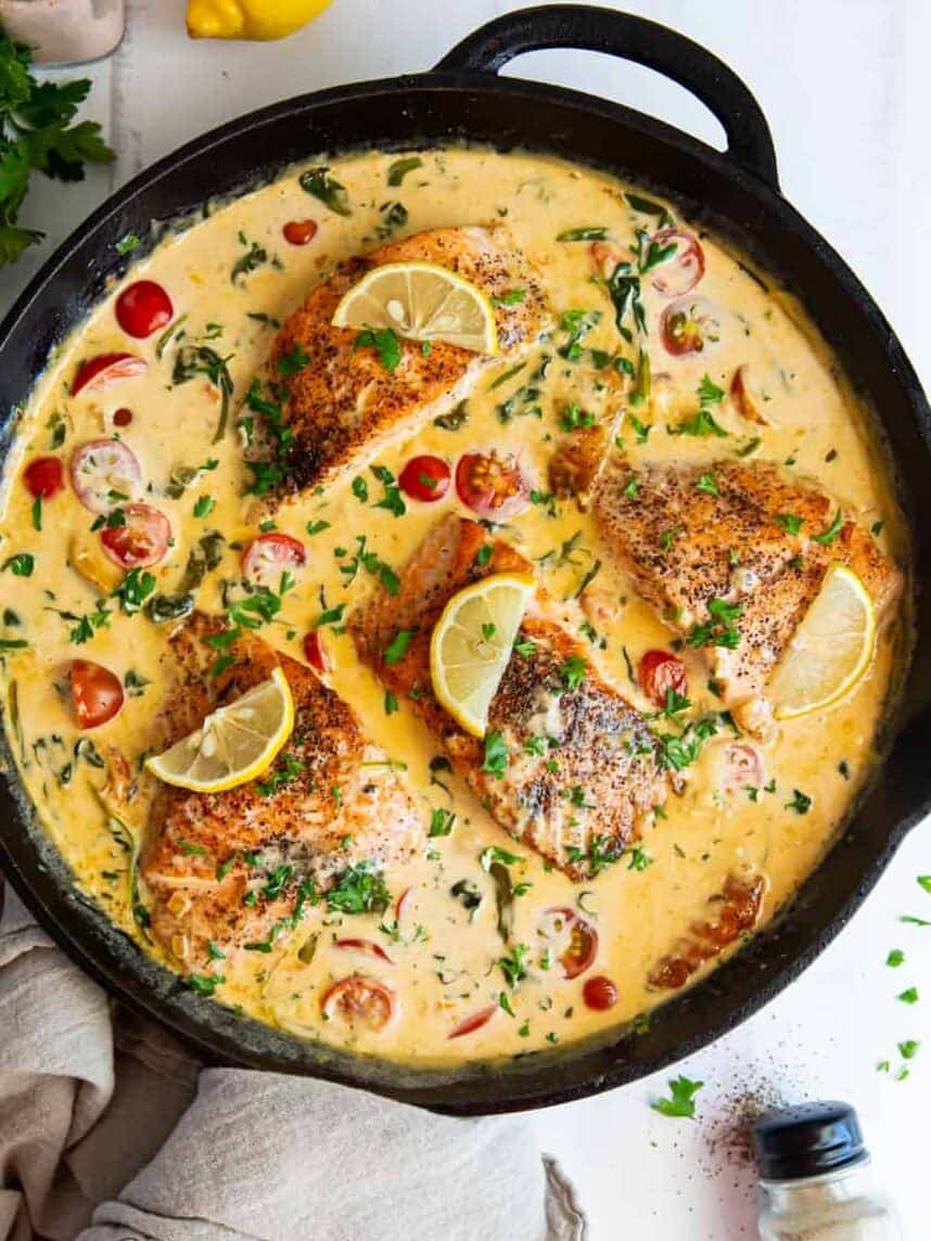 overhead view of 4 pieces of tuscan salmon in a cast iron pan.