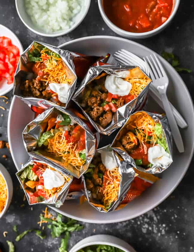 Mexican burritos in foil on a plate.