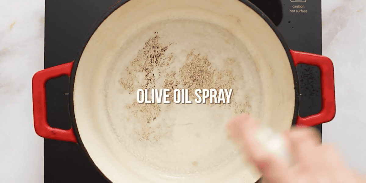 Pot being coated with olive oil spray.