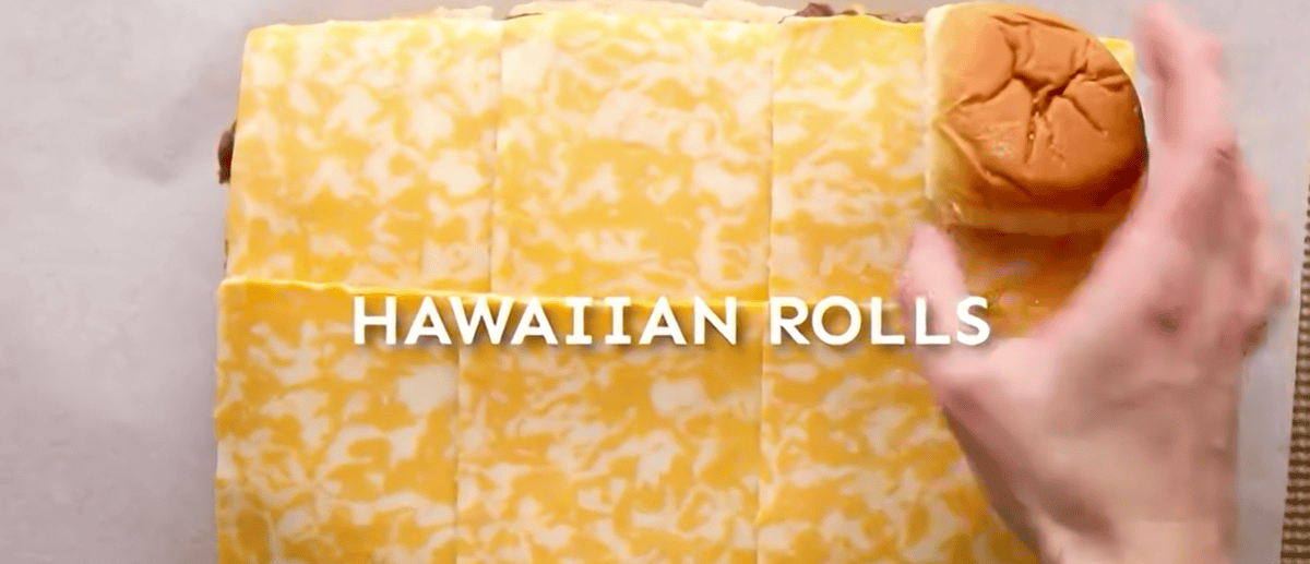 Topping the beef with the onions, cheese and the top half of the buns. 