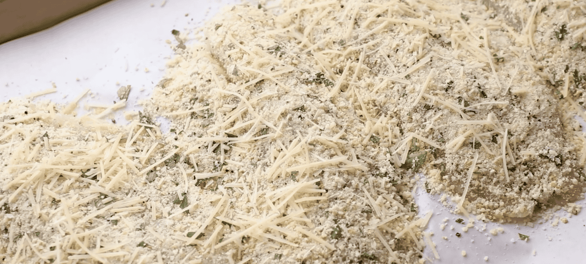 Adding Parmesan to the fish. 