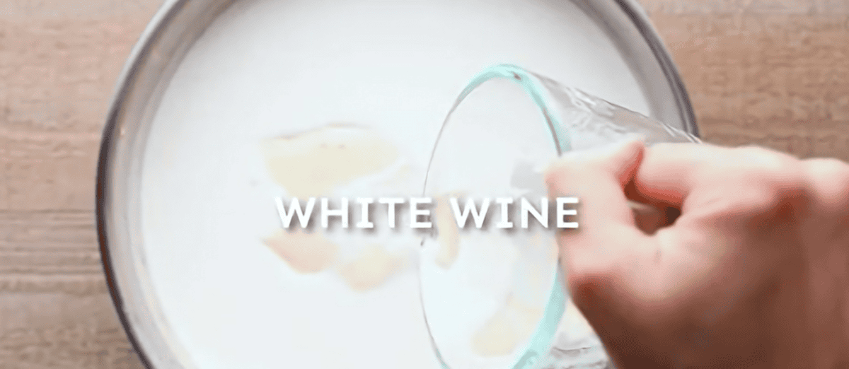 Adding white wine to the white sauce. 