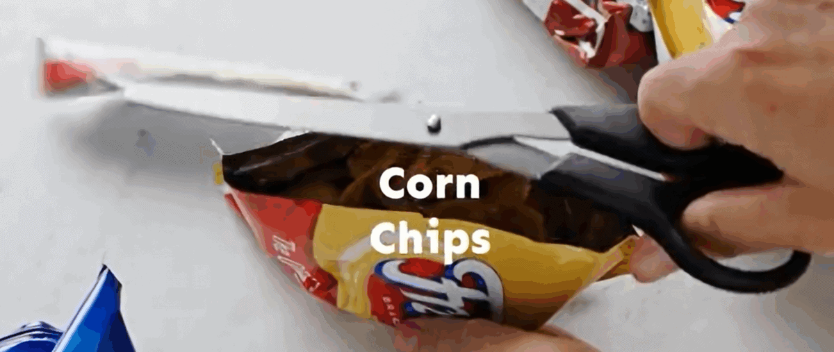 Cutting a bag of corn chips.
