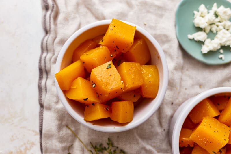 roasted butternut squash cubes in white bowls.