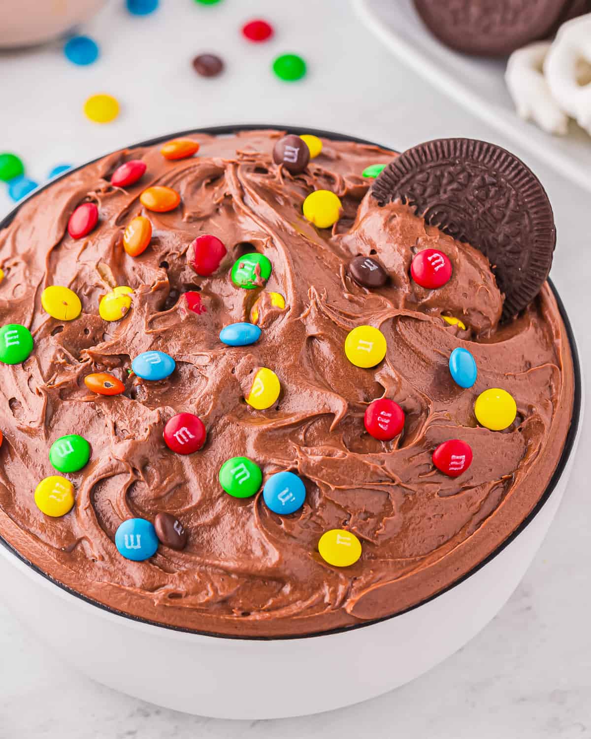 Brownie batter dip topped with M&Ms in a white bowl.