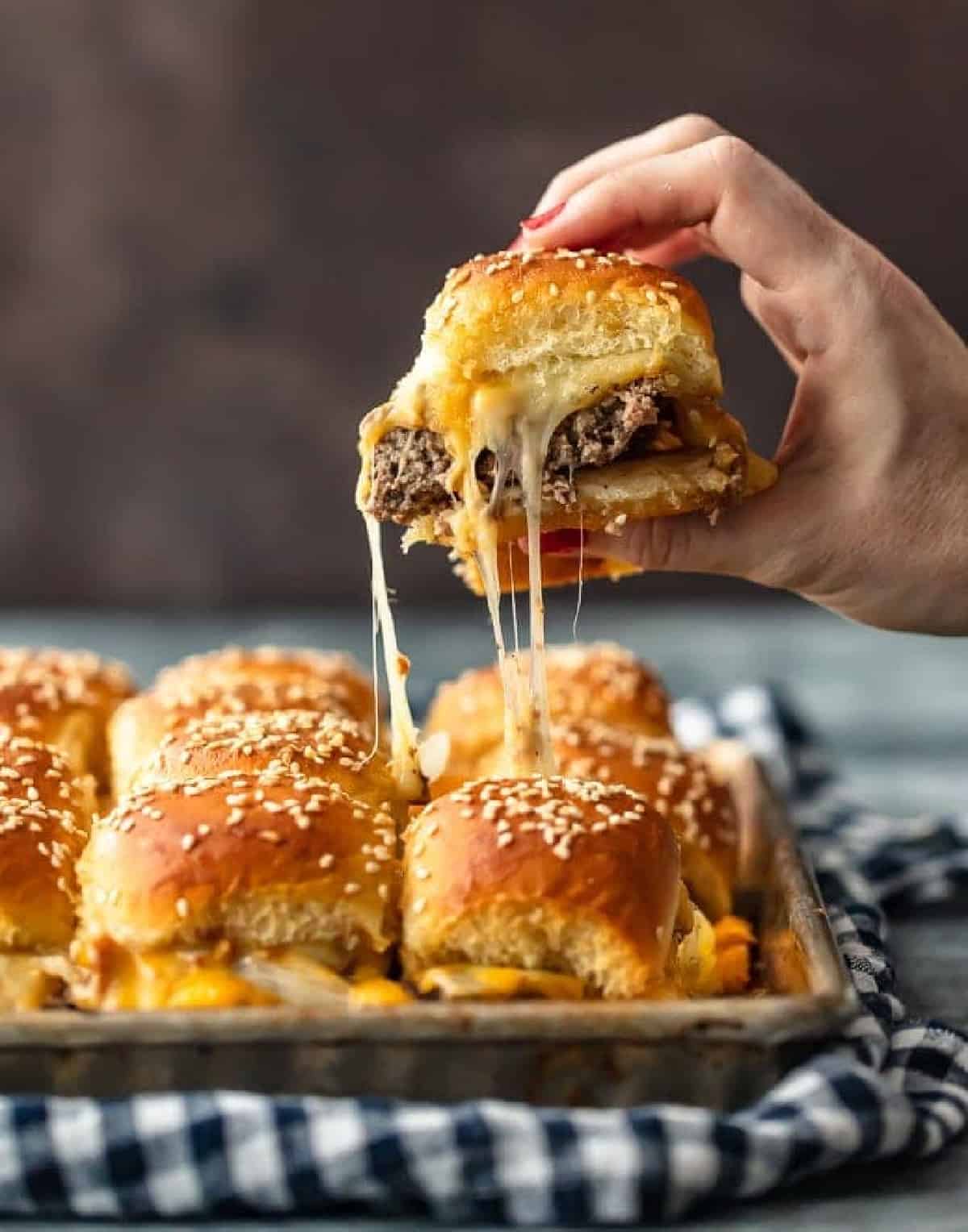 hand lifting up cheeseburger slider