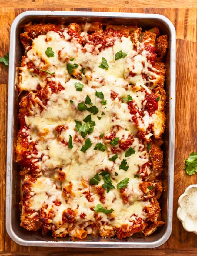Lasagna in a baking dish with cheese and parmesan.