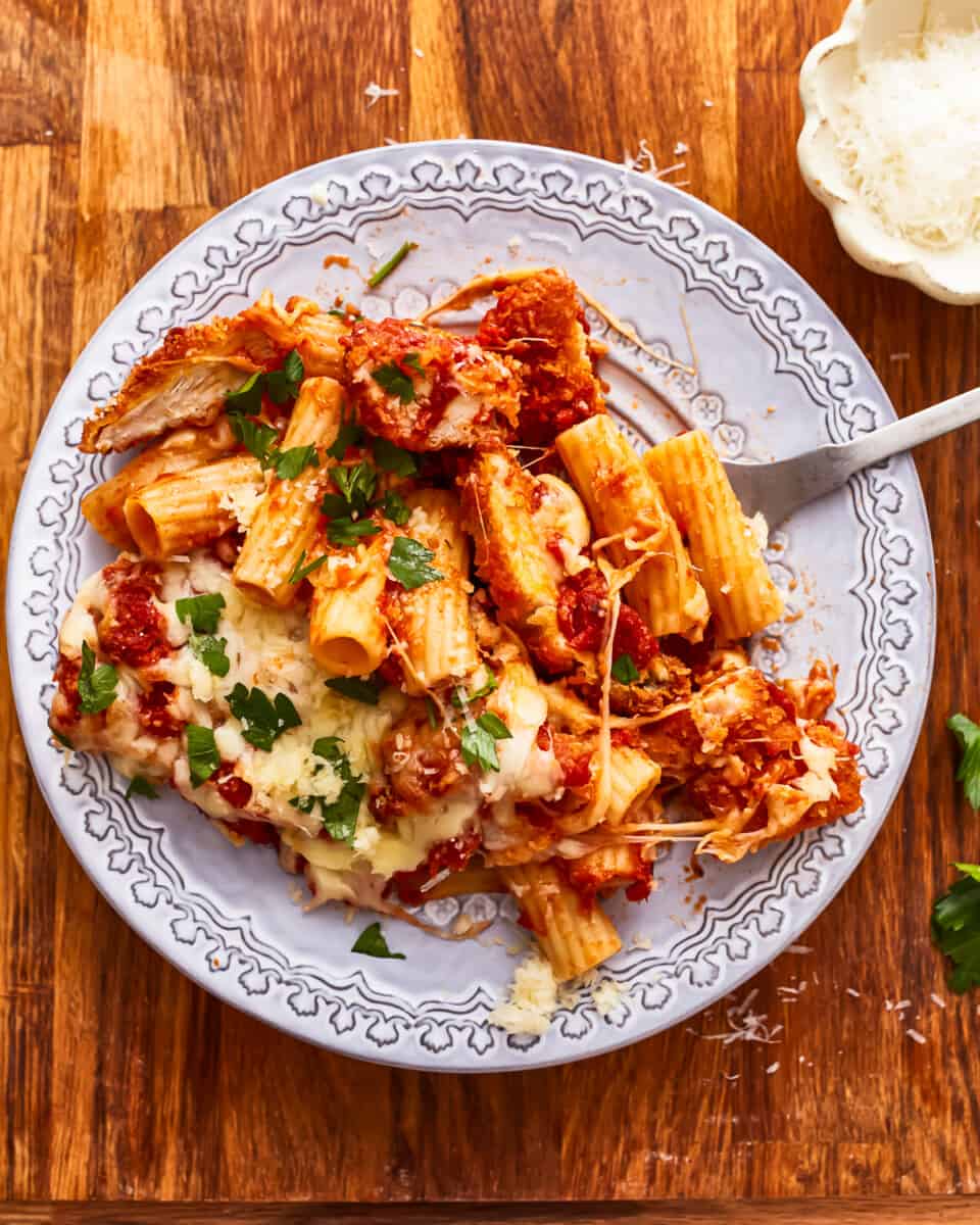 A plate of chicken parmigiana on a wooden table.