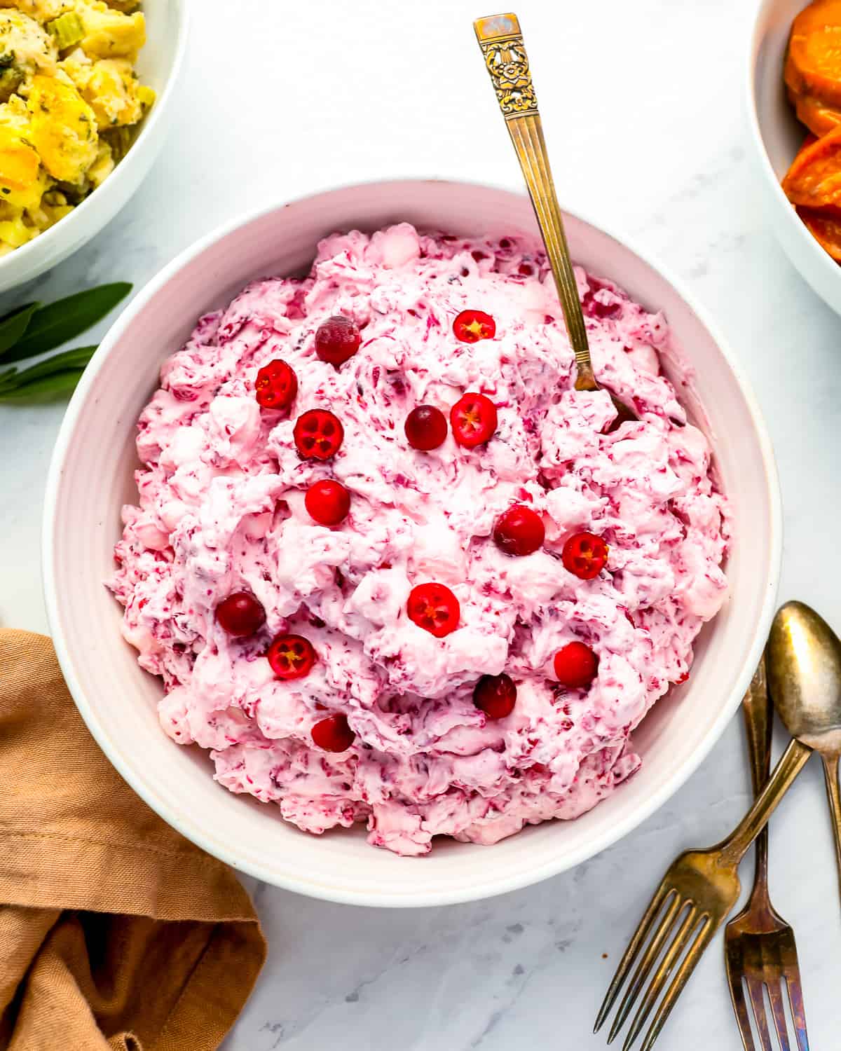 A bowl of cranberry fluff salad with cranberries.